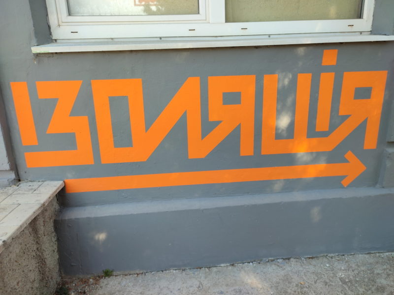 Частина підмурку будівлі, на якій помаранчевим по сірому написано «Ізоляція»