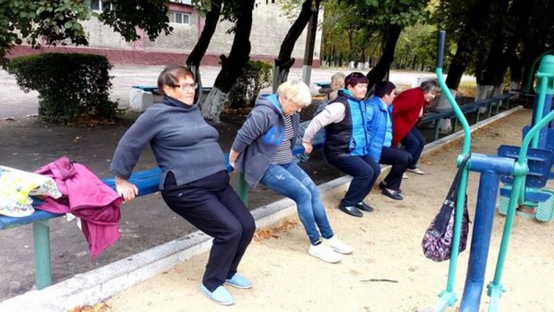 шість жінок пенсійного віку роблять вправи – відтискання від лавки