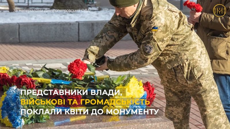 Військовий покладає квіти до монумента
