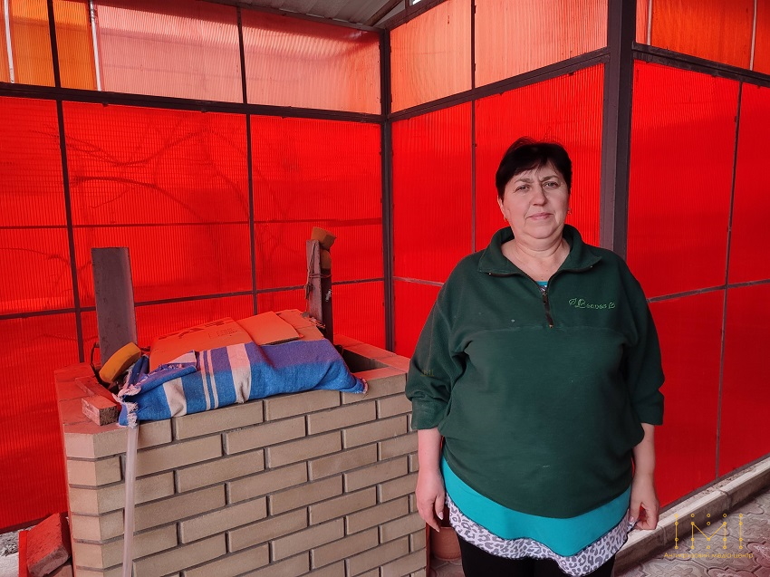 Галина Єгурнова стоїть у павільйоні біля схожої на колодязь споруди