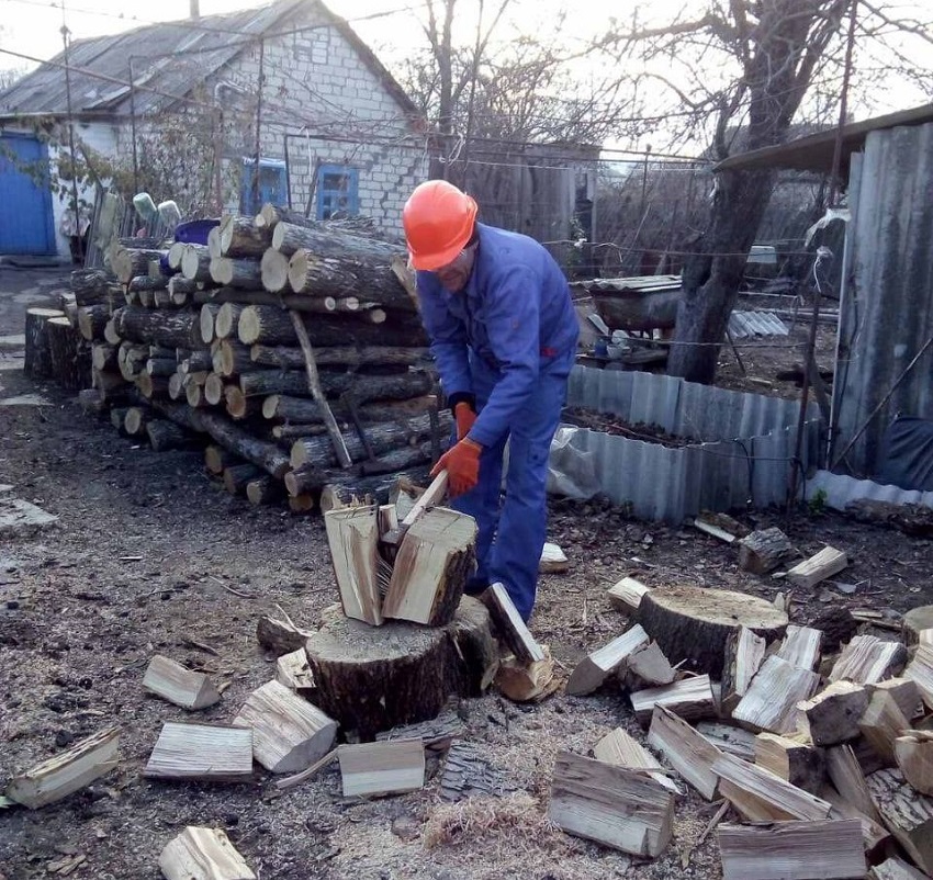 Чоловік рубає дрова.