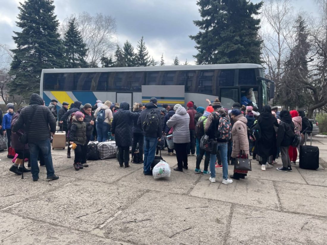 евакуація - люди біля автобуса