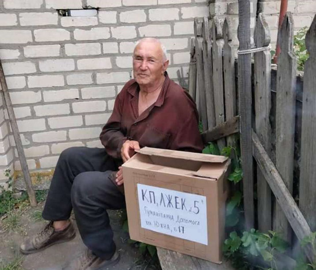 літній чоловік з ящиком гуманітарної допомоги
