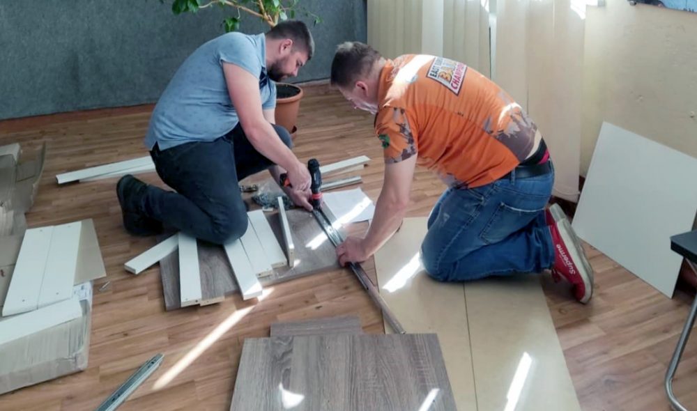 чоловіки ремонтують підлогу